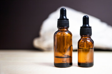 Fototapeta premium Amber glass bottles for cosmetic product on abstract natural background. Side view, space for text.
