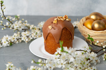 Ester cake with chocolate topping and nuts on gray background