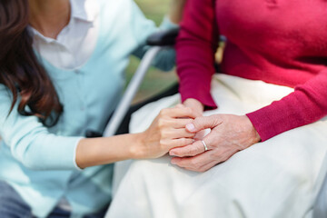 Obraz premium Close up daughter hands holding older senior mother hands, Family care relationship..