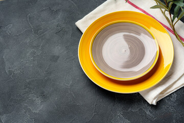 Top view of ceramic plate with table napkin on gray background