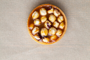 round tartlet with salted caramel and roasted hazelnuts