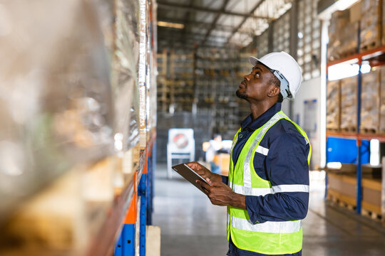 Photo of a male worker inspecting count products stock in a warehouse manufacturing plant for inventory management work