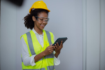 Engineering African American businesswoman holding digital tablet and computer in hands. African American woman builder using touchpad,  Constuction,