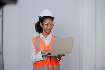Engineering African American businesswoman holding digital tablet and computer in hands. African American woman builder using touchpad,  Constuction,