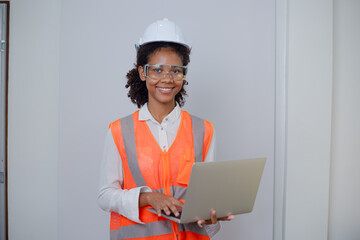 Engineering African American businesswoman holding digital tablet and computer in hands. African American woman builder using touchpad,  Constuction,