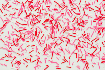 flat lay of pink sprinkles over white background, festive decoration for banner, poster, flyer, card, postcard, cover, brochure, designers