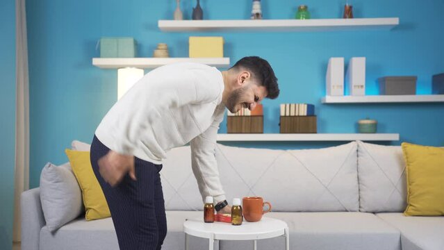 Young man with backache while lifting the table.
When the young man lifts the coffee table, he has pain in his lower back and sits down.

