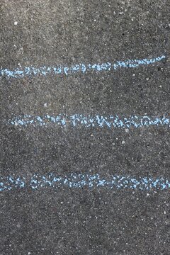 Three lines written on the sidewalk in chalk.
