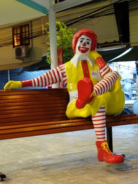 PHUKET, THAILAND - JANUARY 08, 2018: Portrait of of Ronald-Mcdonald sitting on bench in front of McDonald's restaurant.