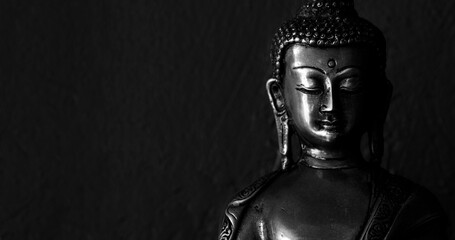 Traditional bronze Buddha statue isolated on black background.