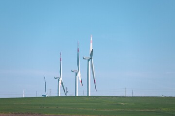 Wind turbine and windmill. Clean energy in green nature in different locations. Sustainability and environment concept  © Bigy