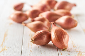 Obraz na płótnie Canvas onions shallots on a white wooden table, selective focus.