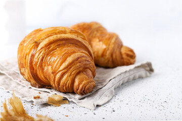 Two croissants on a light background.