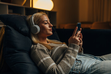 A woman is resting on the sofa in the evening