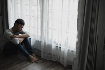 Sad young man sitting in the bedroom, People with depression concept, stressed man,	