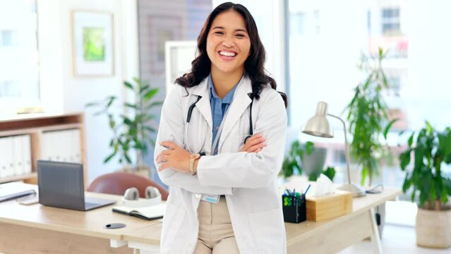 Happy asian woman, doctor and confidence with arms crossed for healthcare on office desk at hospital. Portrait of confident female medical professional standing and smiling in health advice at clinic