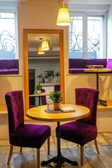cozy stylish interior with purple armchairs wooden tables and a mirror. Horizontal