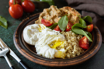 Keto diet. Delicious breakfast or brunch - zucchini vegan waffles, poached egg, quinoa and fresh vegetable salad on a stone tabletop.