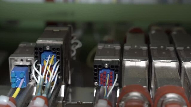 Close up hand held pan of electrical wires and connectors on a 787 commercial airplane.