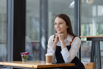 Young business woman cafe owner. Successful owner standing at cafe shop.