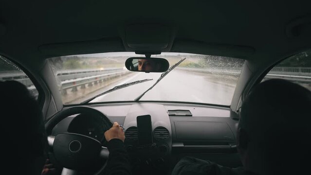 Business people drive oldtimer on highway road at rainy weather. Windshield wiper clean rain drops from glass, slow motion
