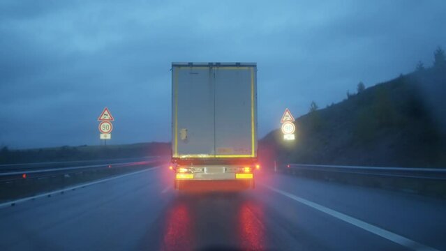 Police officer following an intruder truck doing suspicious activity trafficking of illegal goods on dark highway at night, slow motion cinematic shot