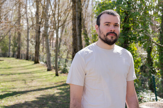 Image of a strong young happy happy young sportsman posing outdoors in nature green park looking towards the camera.