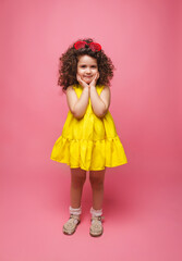portrait of a girl in a yellow dress cute attractive cute cheerful cheerful little girl .isolated pink background.