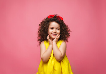 portrait of a girl in a yellow dress cute attractive cute cheerful cheerful little girl .isolated pink background.