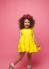 portrait of a girl in a yellow dress cute attractive cute cheerful cheerful little girl .isolated pink background.