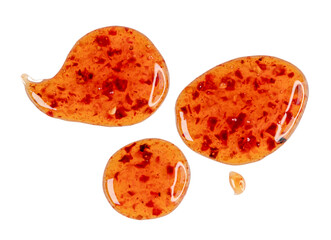 Drops of sour sweet sauce with pieces chilli pepper isolated on white, top view