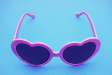 Dark purple-rimmed glasses on a blue background.