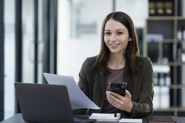 Fototapeta premium Happy excited young successful business woman and working online at the table in office, 