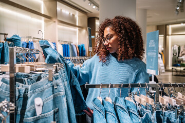 Black woman choosing clothes in shop