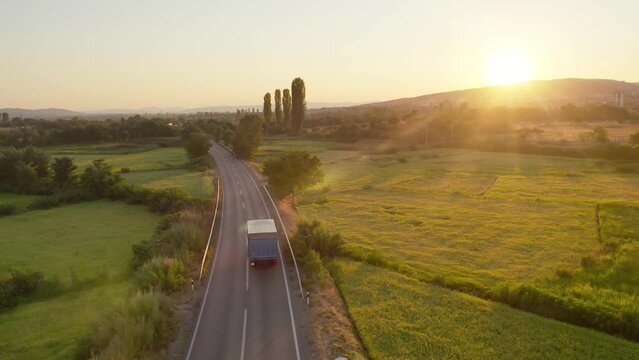 Semi trailer on asphalt road at sunset - transportation background, cinematic aerial shot