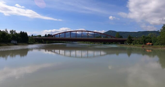 dammed waters of the salzach river in salzburg country at a hydroelectric power station with a modern arched bridge and the mountains of the alps