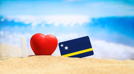 I love Curacao. Flag of Curacao on the beach with a red heart. vacation and travel concept.