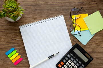 Top view closeup flat lay photo of notepad with blank page isolated on wooden table with succulent and stationery