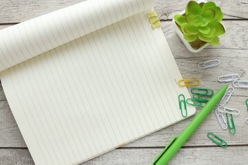 Design concept - Top view of open notebook and hill plant on wooden background for mockup
