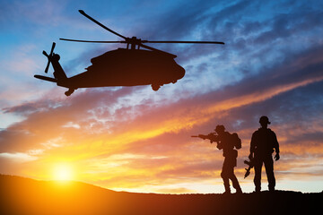 Fototapeta na wymiar Silhouettes of helicopter and soldiers on background of sunset. Greeting card for Veterans Day, Memorial Day, Air Force Day. USA celebration.