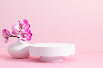Obraz na płótnie Canvas White round podium pedestal cosmetic beauty product goods branding design presentation empty mockup on light pink background with shadows and beautiful pink orchid flowers cosmetic mockup