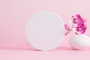 White round podium pedestal cosmetic beauty product goods branding design presentation empty mockup on light pink background with shadows and beautiful pink orchid flowers  cosmetic mockup
