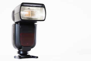 Black speedlight on white stage, photography theme, visual communication, side view