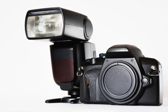 Black camera with speedlight on white stage, photography theme, visual communication, side view