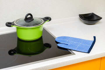 kitchen potholder lies near the hob in the kitchen, shot with shallow depth of field. 