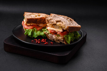 Delicious sandwich with crispy toast, chicken, tomatoes and lettuce