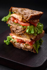 Delicious sandwich with crispy toast, chicken, tomatoes and lettuce