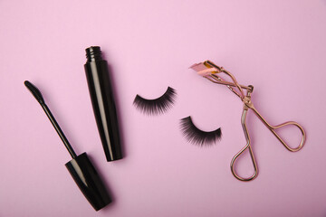 Composition with false eyelashes, mascara and eyelash brushes, eyelash curlers on a lilac background. Makeup artist tools. Beauty concept. Compose. Place for text. Place to copy. Flatley. MOCAP.
