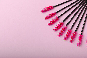 Eyelash extension brushes on a lilac background. Brush for combing extended and false eyelashes. Brush for straightening eyelashes and eyebrows.