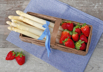 Frischer weißer Spargel mit Erdbeeren in einem Korb.